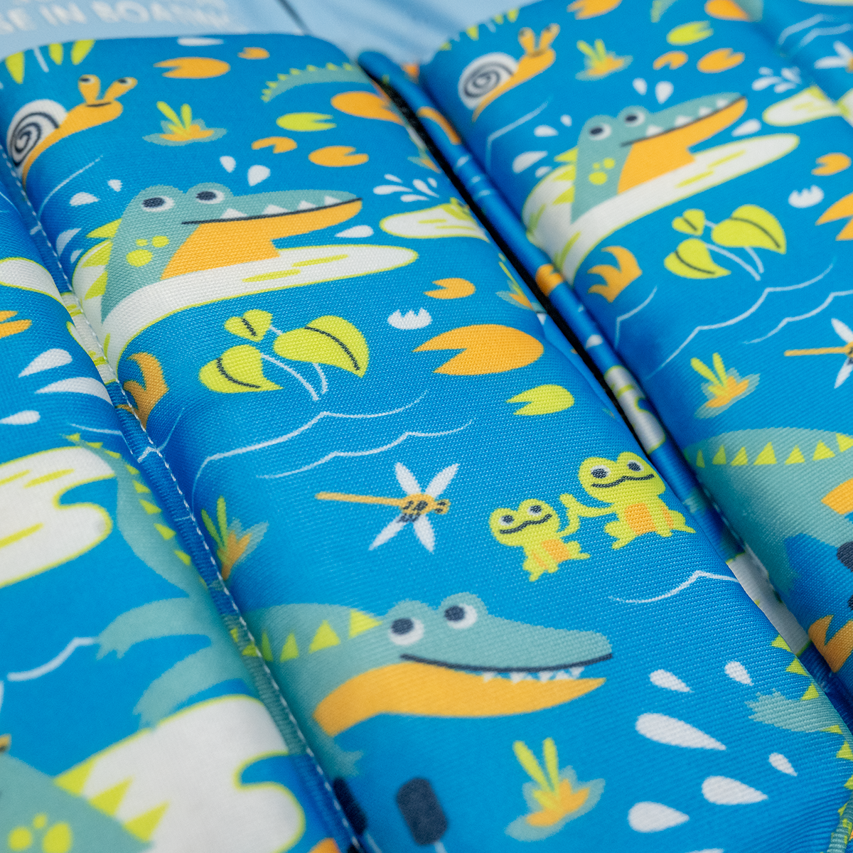 Close up image of the crocodile swamp designs on the sleeved floatsuit
